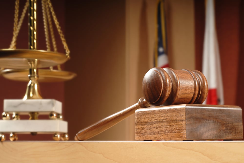 Scales of justice and a gavel on a courtroom bench