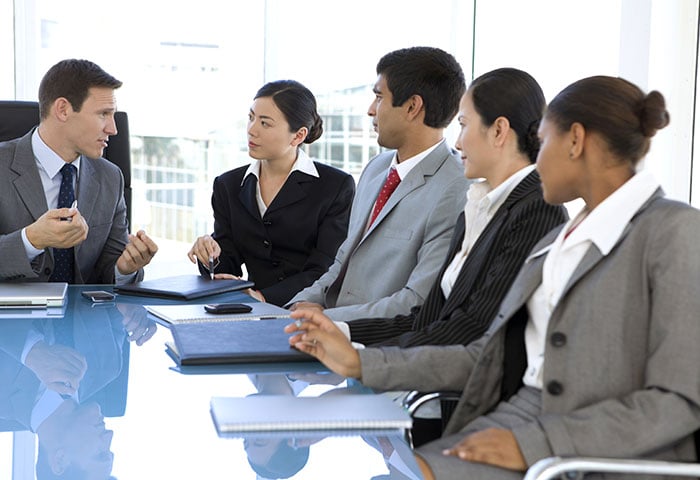 A department head in a meeting room with his members.