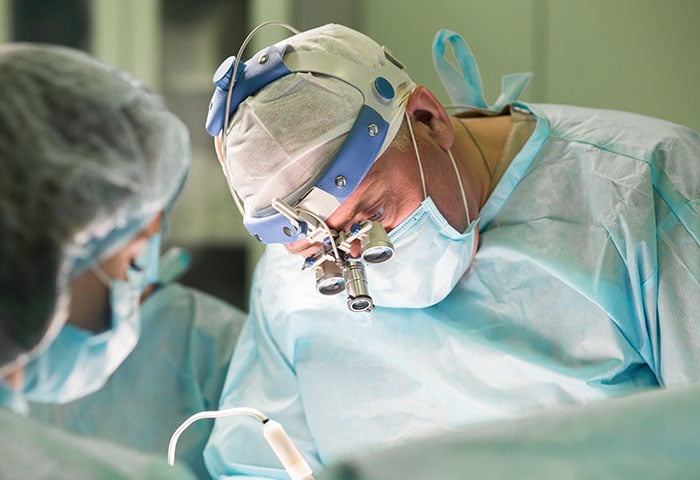 A surgeon on an operating room performing a procedure.
