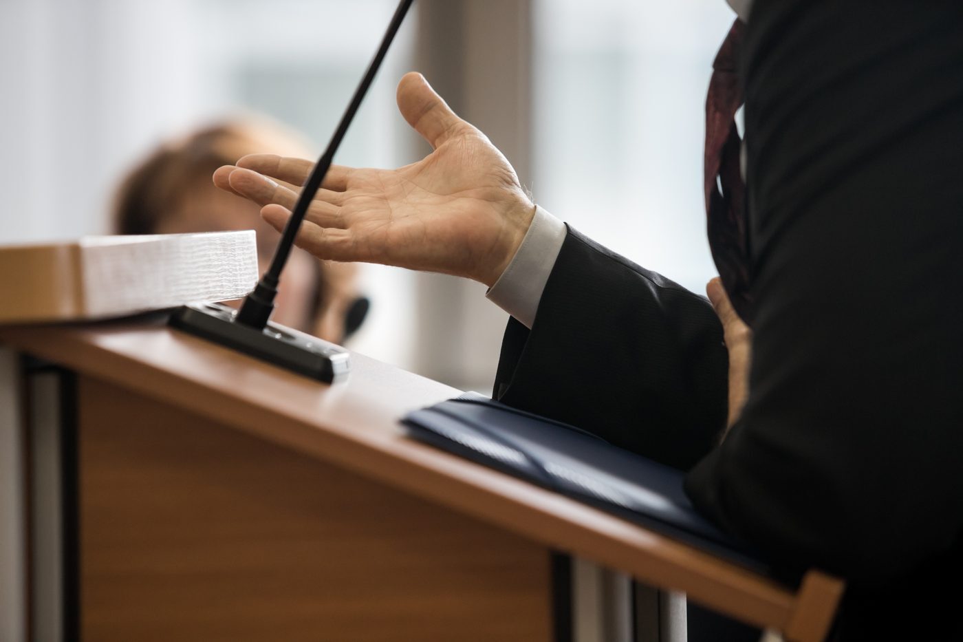 Attorney gesturing while speaking at a podium