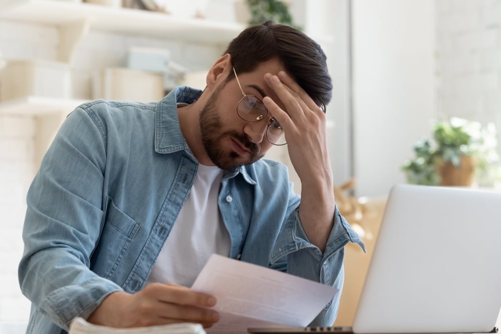 worried-young-man-holding-legal-document